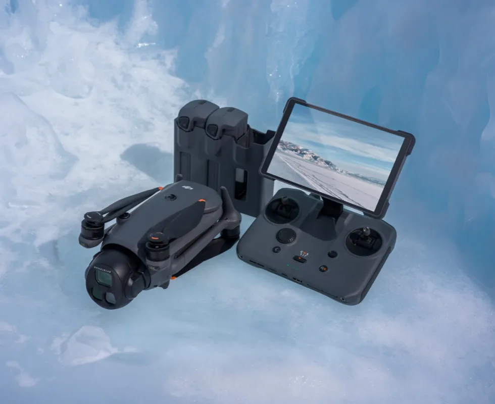 Zusammengefaltete DJI Mavic 4 Pro, zwei Akkus und die DJI RC Pro 2 mit aufgeklapptem Bildschirm auf Eis